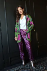 Pantalón babucha de símil cuero metalizado color violeta, con cintura elastizada ajustable con cordón.