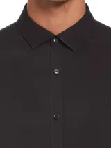 Camisa negra de manga larga con cierre de botones, puños con botón y logo bordado.