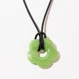 Collar con dije de flor verde y cordón negro.