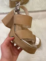Sandalias de plataforma color beige con tiras anchas y hebilla metálica.
