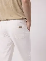 Pantalón de vestir color beige, de corte recto, con bolsillos laterales y traseros. Se ajusta a la cintura con botón y cierre.