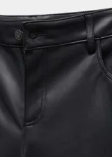 Pantalón largo de tiro medio, color negro, con efecto piel, diseño recto, trabillas, cinco bolsillos y cierre de cremallera y botón.