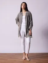 Camisa de jean celeste, marca Hester & Orchand, de corte oversize con cuello con solapa, escote en V y abertura central con botones. Delantera con bolsillos aplicados, mangas largas regulables con presilla y botón, y ruedo desflecado.