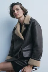 Abrigo de Zara Woman Collection, con cuello solapa de muescas y manga larga. Bolsillos con solapa en delantero. Interior en borreguillo combinado a contraste. Cierre frontal cruzado con botones.