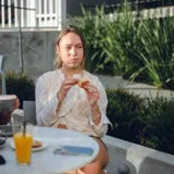 Chaleco corto color crema con escote en V, sisa redonda y cierre delantero con botones.