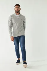 Sweater gris de punto con medio cierre, cuello alto y logo bordado en el pecho.