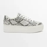 Championes urbanos con plataforma, de animal print color marrón y negro, con cordones dorados y cierre de cremallera lateral con tirador circular.