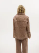 Campera de denim gastado color celeste, con cuello camisero, corte holgado y canesú con costuras delante y atrás.