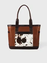 Bolso tipo tote de cuero color marrón con aplique de cuero con estampado animal print en el frente. Tiene bolsillos laterales y bolsillo interno con cierre. Hecho en Uruguay.