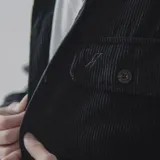 Camisa celeste de pana con corte oversize, cuello clásico, cierre frontal con botones, dos bolsillos con solapa en el pecho y mangas largas con puños abotonados.
