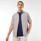 Camisa marrón claro de manga corta con cuello clásico y cierre abotonado.