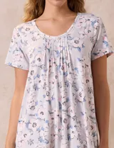 Camisón corto negro con lunares blancos, de tejido suave y escote redondo con detalle plisado y moño blanco.