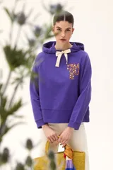 Buzo violeta con capucha y lazo de ajuste color crema. Estampado frontal con la frase "L'Amour" en letras con diseño animal print.