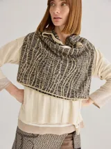 Buzo de punto color beige con diseño geométrico en negro. Incluye cuello alto y falda cruzada a juego.