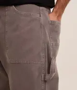 Pantalón baggy de sarga color gris con efecto marmolado, tiro alto, bolsillos laterales y traseros, y trabillas en la cintura.