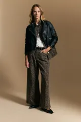 Campera negra de cuero sintético estilo biker, con cierre asimétrico, broches metálicos en el cuello y bolsillos con cierre.