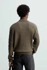 Polo color verde oliva de corte regular, tejido de punto con mezcla de algodón y cashmere. Tiene cuello solapa con cierre frontal de botonadura, manga larga y acabados en rib.