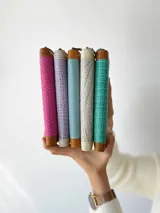 Billetera de cuero fucsia y marrón con cierre metálico y monedero interno.