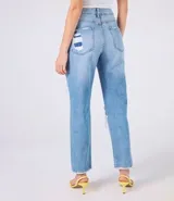 Pantalón de jeans celeste con corte mom, tiro alto, bolsillos delanteros y traseros, y roturas grandes en ambas rodillas.