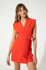 Vestido corto color coral, estilo blazer sin mangas, con cuello en V cruzado, doble botonadura y cinturón al tono.