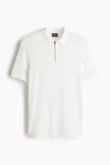Remera polo blanca de punto fino en mezcla de algodón y viscosa, con cuello acanalado, medio cierre con cremallera y mangas raglán cortas. Corte slim fit.