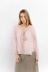 Blusa rosa de algodón con escote en V con cordones y detalle de volados.
