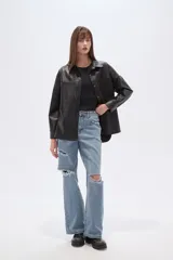 Sobrecamisa negra de efecto cuero, con cuello camisero, botones frontales y dos bolsillos de parche con solapa en el pecho. Presenta un calce holgado.