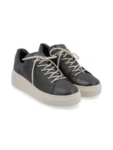 Sneaker Adelaida de cuero graneado color verde oliva, con cordones de algodón y suela elevada color crema.