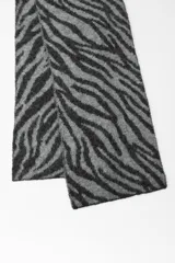 Bufanda rectangular de punto con estampado de cebra en tonos grises y negros.