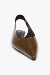 Zapato destalonado tipo bailarina, color marrón, de piel, con punta fina y tira trasera con elástico lateral.
