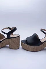 Sandalias negras de cuero con plataforma de yute y pulsera al tobillo.