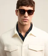 Campera trucker masculina de jeans color crudo, con cuello solapa, abotonado delantero, bolsillos con solapa y superficie lisa.