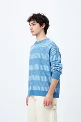 Sweater tejido en jacquard con diseño de franjas geométricas en tonos de azul.