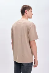 Remera manga corta oversize color taupe con estampa frontal de un sol y la frase 'Bold Sun'.