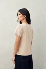 Remera blanca de algodón con cuello redondo y costuras verticales en el frente.