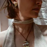 Par de aros colgantes de bronce y alpaca con diseño abstracto calado.