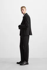 Pantalón de vestir negro slim fit, confeccionado en tejido con viscosa. Cuenta con bolsillos frontales y traseros de vivo. El cierre es frontal con cremallera y botón.