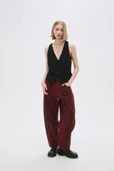 Pantalón de jean de tiro alto con estampado animal print de cebra en tonos borgoña y negro.