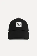 Gorra negra de algodón con visera y parche bordado con el logo "50" y la leyenda "A Coruña".