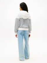 Buzo con capucha Tommy Jeans para mujer, con cierre frontal, diseño a rayas horizontales blancas y azul marino, y logo bordado en el pecho.