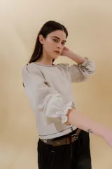 Blusa color beige de lino 100% con mangas balloon y detalle de tablón en el hombro. Tiene mangas largas con detalle de 2 pespuntes elásticos en contratono, el recurso del elástico es ideal para remangarse la manga generar más volumen. Calce recto, largo por arriba de la cadera.