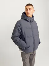 Campera puffer gris con capucha ajustable y bolsillos frontales.