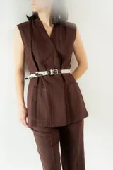 Cinturón de cuero con estampado animal print y tachas plateadas.