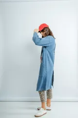 Tapado largo de jeans azul con bordado en la espalda, cuello camisero, bolsillos laterales y cierre frontal con botones.