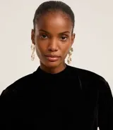 Blusa boxy de terciopelo negro con cuello alto y mangas cortas amplias.