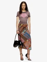 Remera ajustada de manga corta, color blanco hueso, con cuello redondo. Presenta un estampado central de un corazón rojo con el logo de Diesel en su interior.