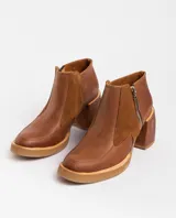 Botas cortas de cuero negro con textura de piel de serpiente, cierre lateral con cremallera, taco de madera forrado en cuero y punta fina.