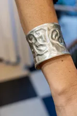 Brazalete ancho plateado con textura labrada.