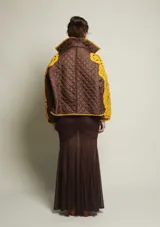 Campera de nylon marrón con cierre delantero intervenido y bordado a mano con hilo de algodón color amarillo.