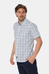 Camisa de manga corta con cuello abotonado y estampado a cuadros en tonos blanco y azul. Hecha en Uruguay.